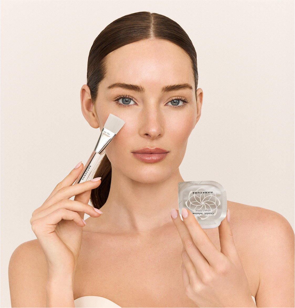Woman holding a Hanacure brush near her face